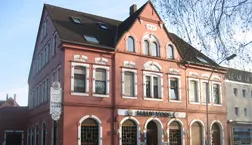Rot gestrichene Klinkerfassade mit farblich hervorgehobenen Stuckornamenten