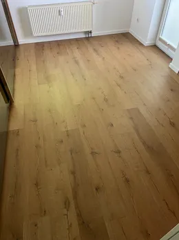 Verlegter Bodenbelag in Holzoptik in einem hellen Zimmer